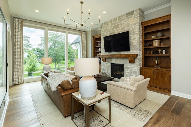 living room featuring ornamental molding, a notable chandelier, a stone fireplace, and hardwood / wood-style flooring