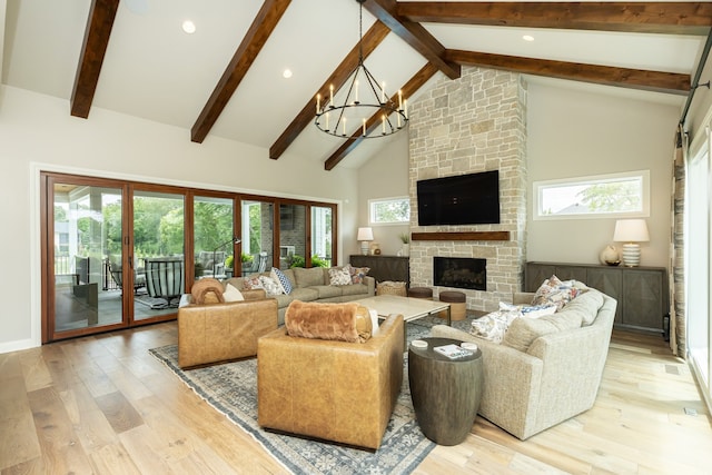 living room with a fireplace, light wood-type flooring, high vaulted ceiling, and a healthy amount of sunlight