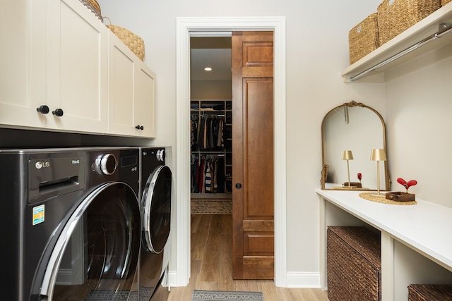 laundry room with cabinets, separate washer and dryer, and light hardwood / wood-style floors