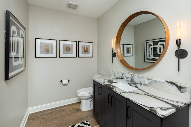 bathroom with vanity, toilet, and hardwood / wood-style floors