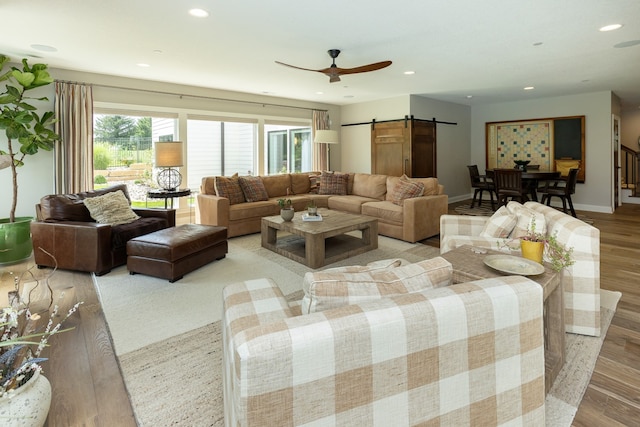 living room with a barn door and light hardwood / wood-style flooring