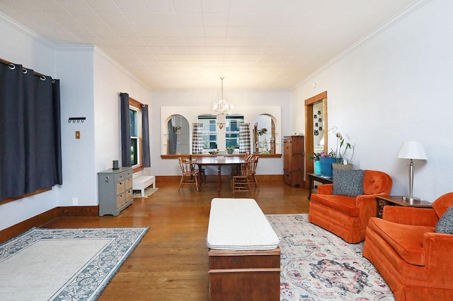 living room with dark hardwood / wood-style flooring, an inviting chandelier, and ornamental molding