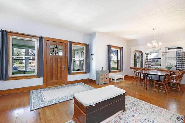 living room featuring a chandelier, wood-type flooring, and a healthy amount of sunlight