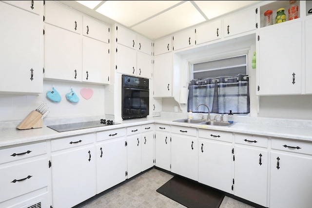 kitchen with sink, white cabinetry, and black appliances