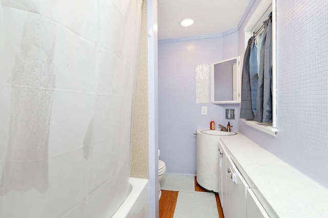 full bathroom with ornamental molding, vanity, shower / tub combo with curtain, wood-type flooring, and toilet