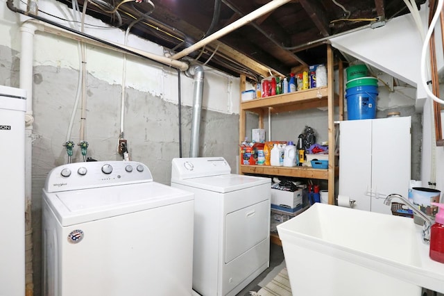 clothes washing area featuring separate washer and dryer and sink