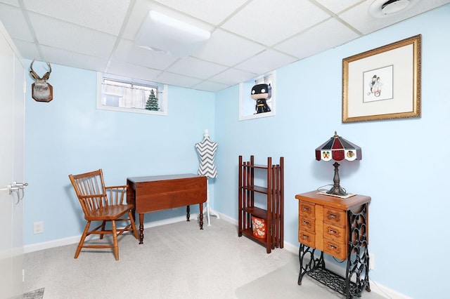 sitting room with a paneled ceiling and carpet