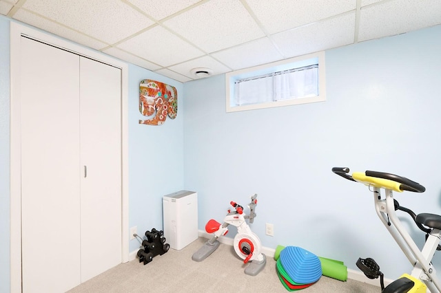 exercise room with carpet flooring and a paneled ceiling