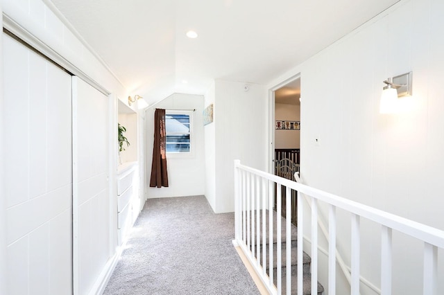 hallway with light colored carpet and lofted ceiling