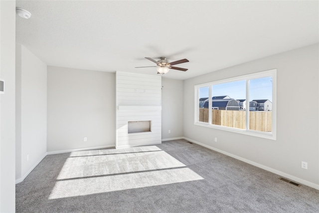 unfurnished living room featuring ceiling fan and light colored carpet