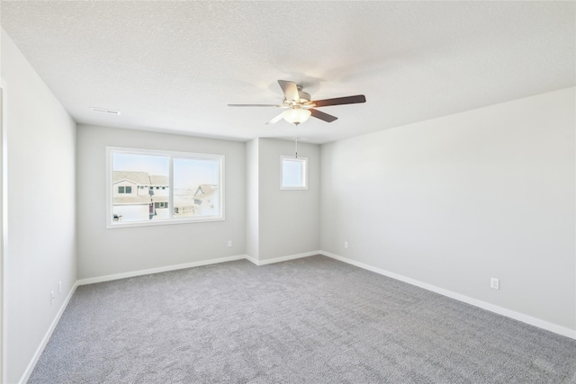 unfurnished room featuring a textured ceiling, ceiling fan, and carpet