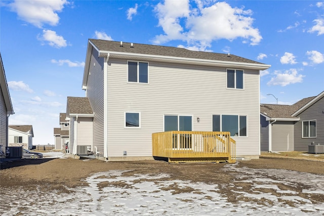 snow covered property with a wooden deck and central AC unit