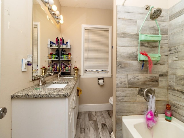 bathroom featuring a tub to relax in, toilet, vanity, and hardwood / wood-style flooring