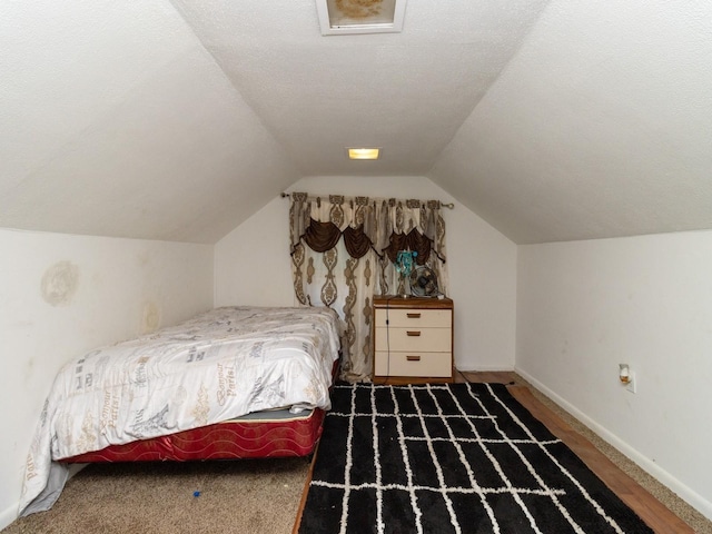 bedroom featuring carpet floors, a textured ceiling, and vaulted ceiling