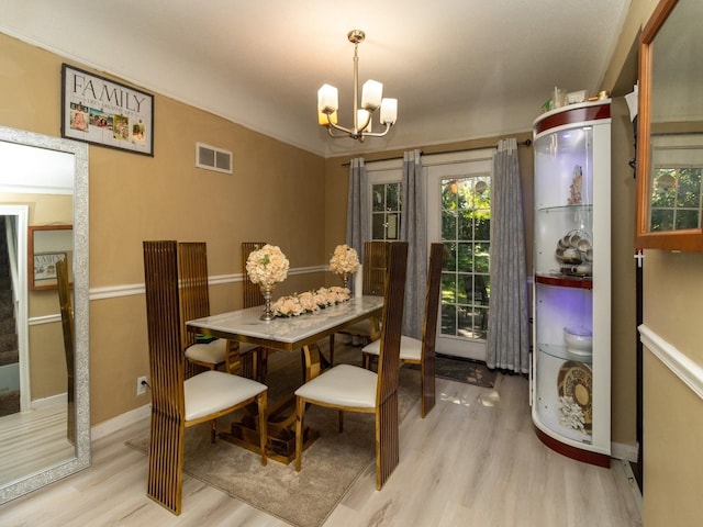 dining area featuring a chandelier, light hardwood / wood-style floors, and ornamental molding