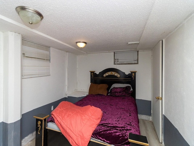 bedroom featuring light wood-type flooring and a textured ceiling