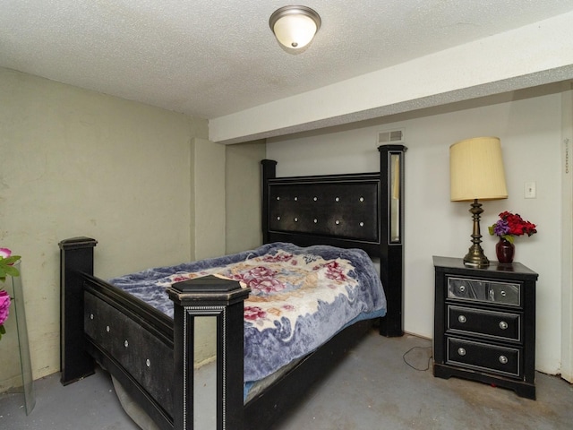 bedroom with concrete floors and a textured ceiling