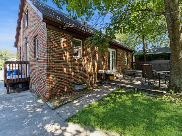 5820 Urbandale Ave, Des Moines, IA 50322 - view of home's exterior featuring brick siding, a wooden deck, and a yard