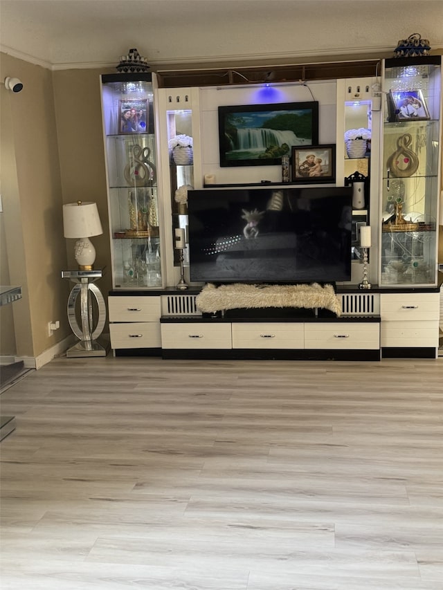 living room with light hardwood / wood-style flooring and ornamental molding