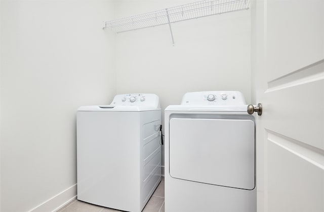 laundry area featuring light tile patterned flooring and washing machine and dryer