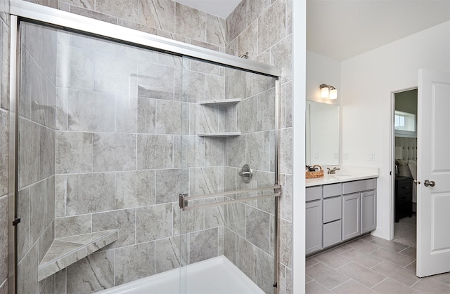 bathroom featuring tile patterned flooring, vanity, and a shower with door