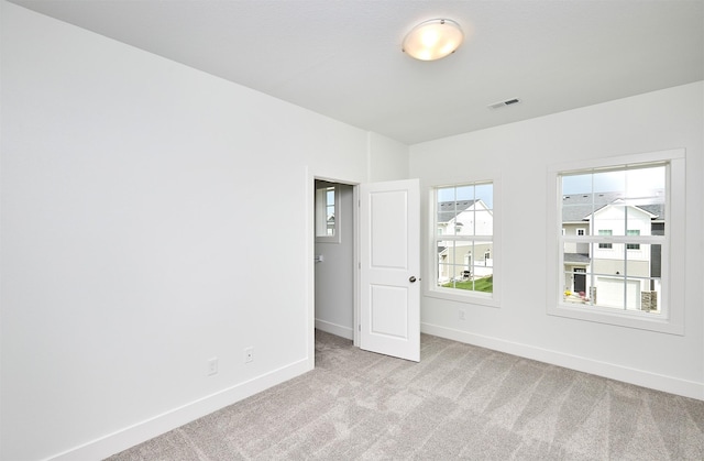 spare room featuring light carpet