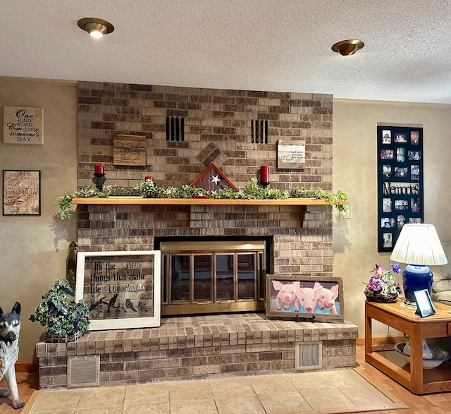 tiled living room with a textured ceiling and a brick fireplace