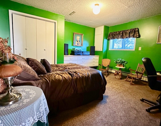 carpeted bedroom with a baseboard heating unit, a textured ceiling, and a closet