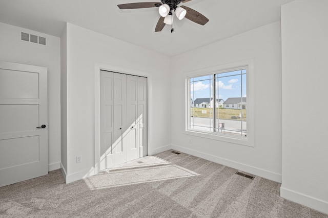 carpeted empty room featuring ceiling fan