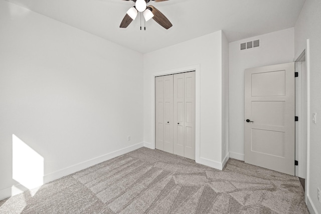 unfurnished bedroom with ceiling fan, a closet, and light colored carpet