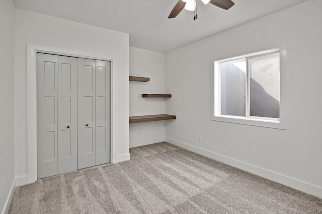 unfurnished bedroom with ceiling fan, light carpet, and a closet