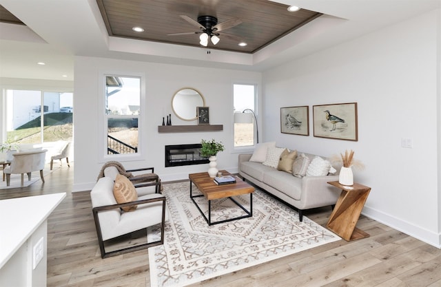 living room featuring a tray ceiling, ceiling fan, wood ceiling, and light hardwood / wood-style floors