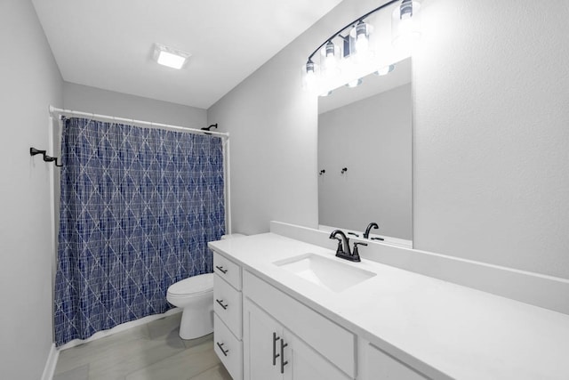 bathroom with tile patterned floors, vanity, toilet, and walk in shower