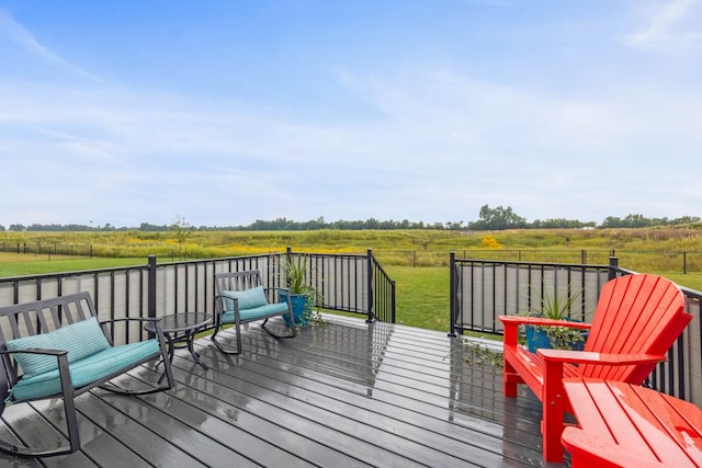 deck featuring a lawn and a rural view