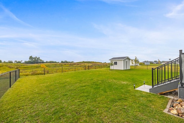 view of yard featuring a rural view and a storage shed