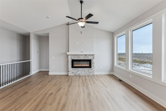 unfurnished living room featuring a fireplace, ceiling fan, light hardwood / wood-style flooring, and vaulted ceiling