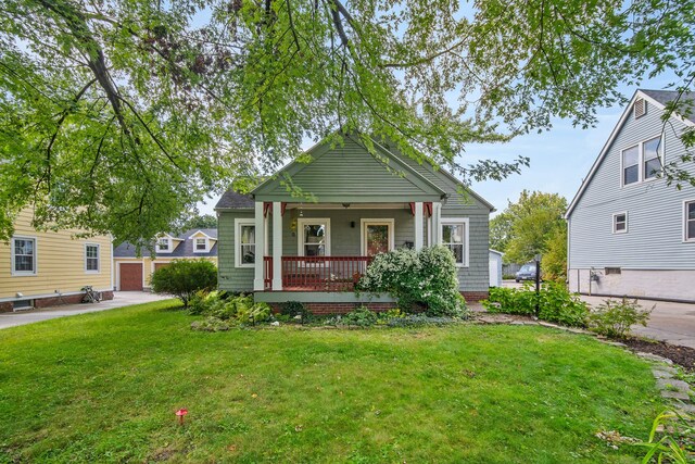 bungalow-style house featuring a front lawn, covered porch, and a garage