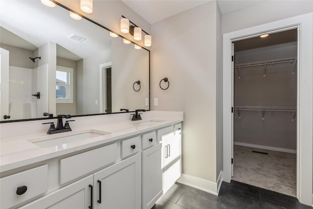 bathroom featuring tile patterned flooring, a shower, and vanity