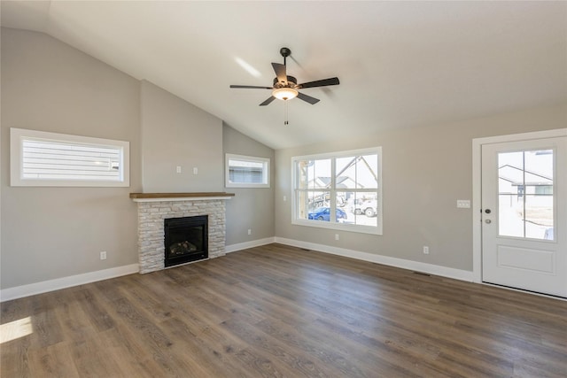 unfurnished living room with a stone fireplace, lofted ceiling, ceiling fan, and dark hardwood / wood-style floors