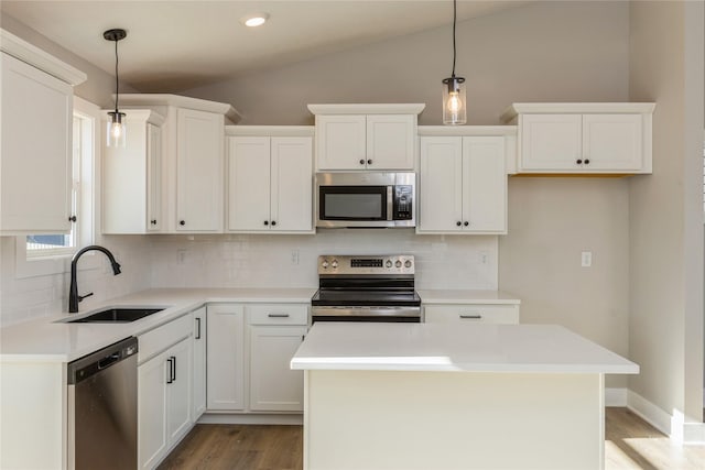 kitchen featuring white cabinets, lofted ceiling, stainless steel appliances, and hanging light fixtures