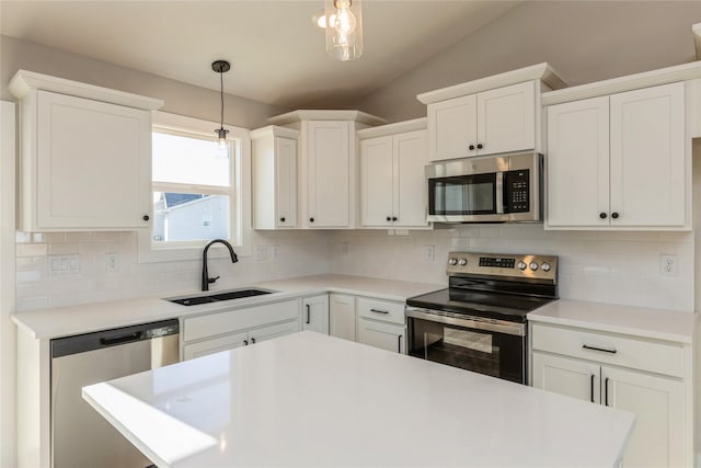 kitchen featuring white cabinetry, decorative backsplash, hanging light fixtures, and appliances with stainless steel finishes