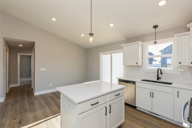 kitchen with stainless steel dishwasher, decorative light fixtures, a kitchen island, and sink