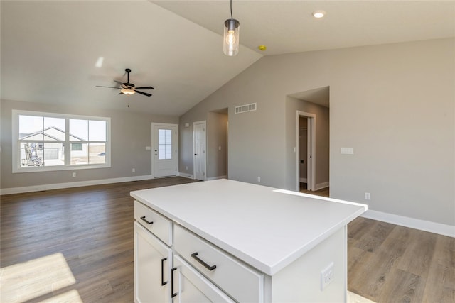 kitchen with pendant lighting, a center island, light hardwood / wood-style flooring, vaulted ceiling, and white cabinetry