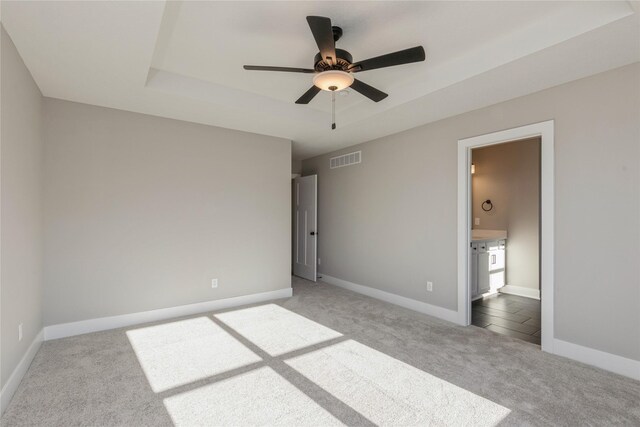 unfurnished bedroom featuring ensuite bathroom, ceiling fan, and light colored carpet