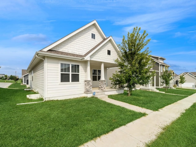 view of front of house with covered porch, a front lawn, and a shingled roof