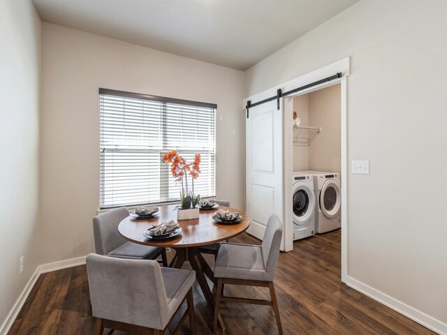 dining room with dark wood-type flooring, washer and dryer, and a barn door