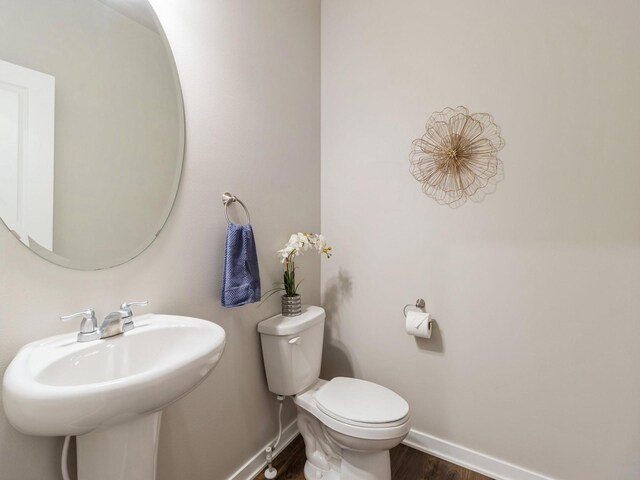 bathroom with toilet, hardwood / wood-style flooring, and sink