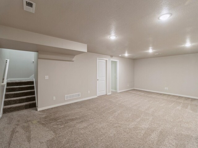 basement featuring carpet flooring and a textured ceiling