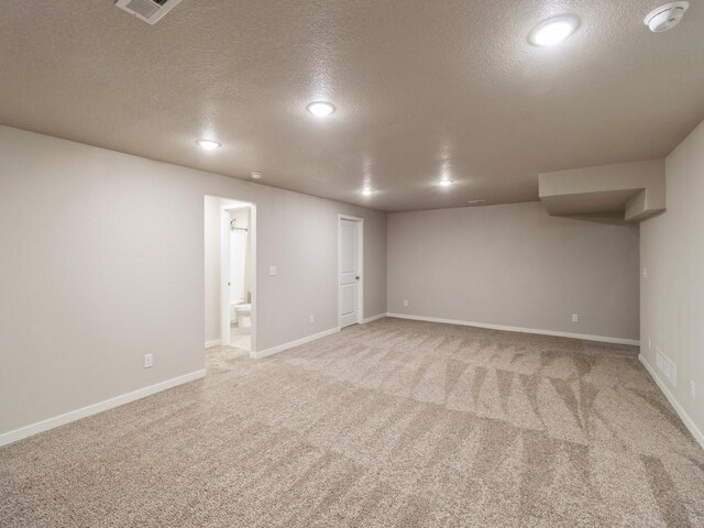 basement with light carpet and a textured ceiling