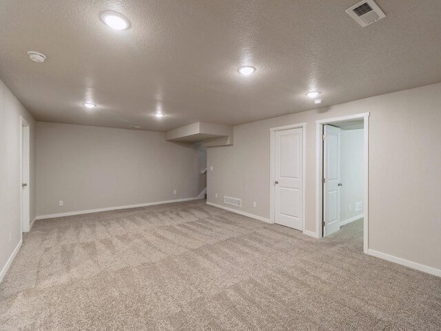 basement with light carpet and a textured ceiling